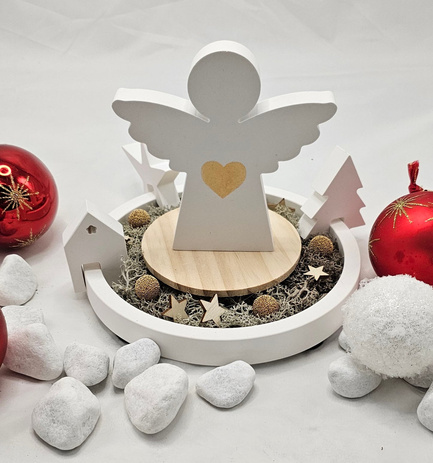 Engel auf Dekoteller, mit Einhänger Tanne, Stern und Haus, festlich dekoriert.