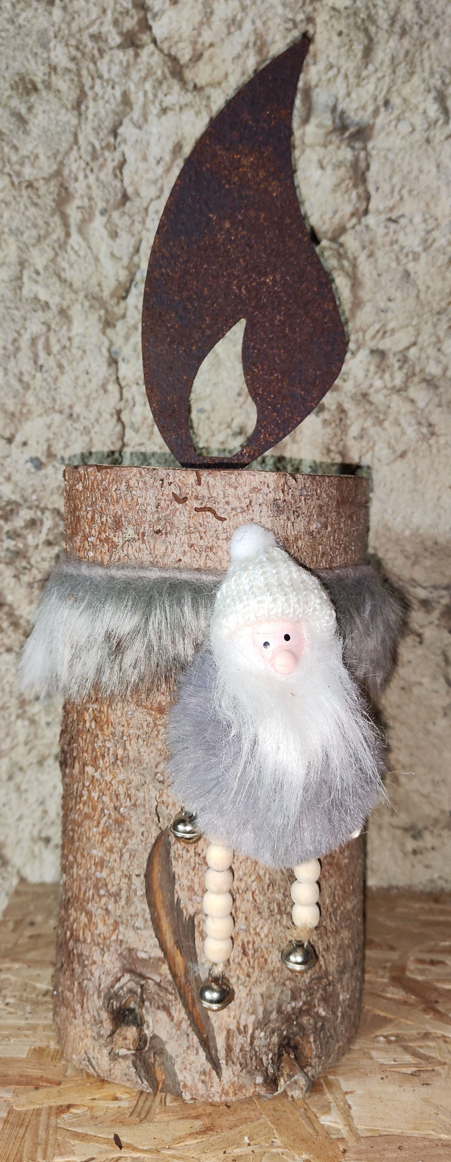 Rostkerze, Rostflamme, Edelrost Flamme in Rostoptik weihnachtlich, winterlich auf Baumstamm dekoriert, Weihnachten, Deko.