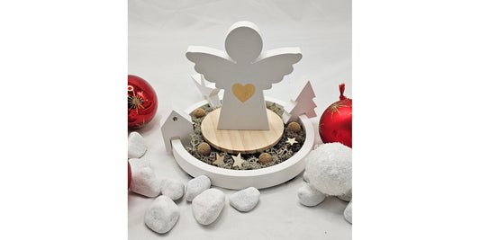Engel auf Dekoteller, mit Einhänger Tanne, Stern und Haus, festlich dekoriert.
