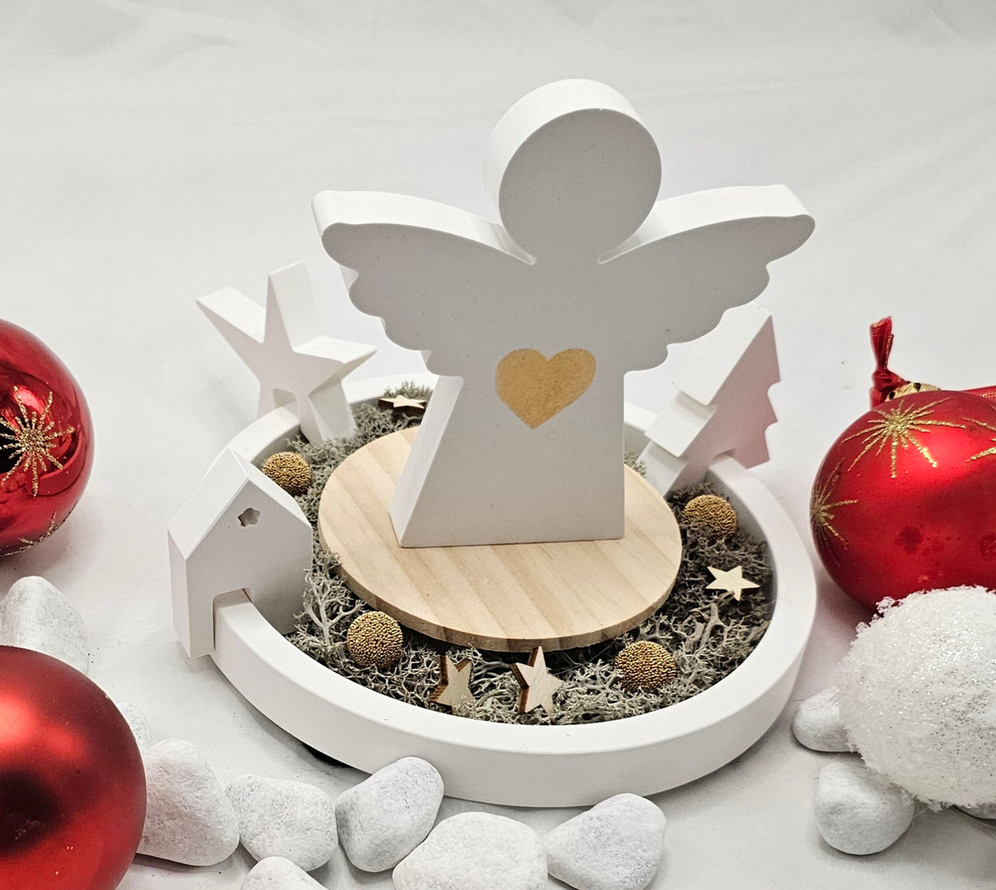 Engel auf Dekoteller, mit Einhänger Tanne, Stern und Haus, festlich dekoriert.