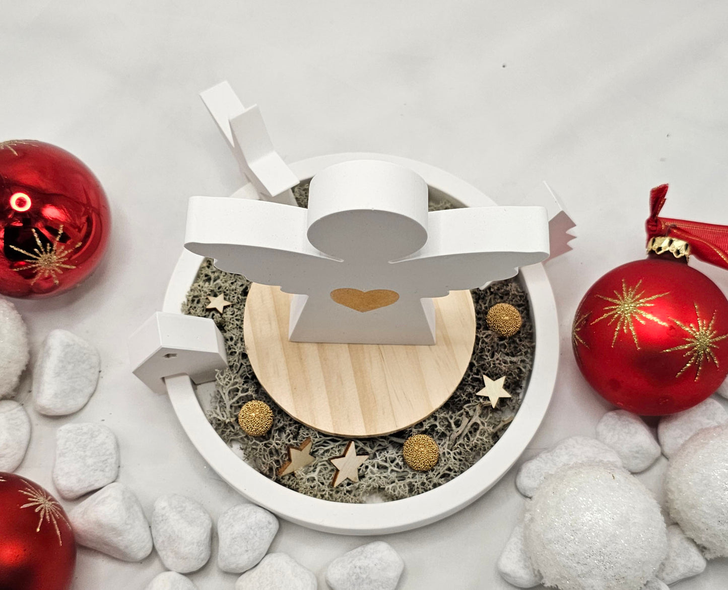 Engel auf Dekoteller, mit Einhänger Tanne, Stern und Haus, festlich dekoriert.