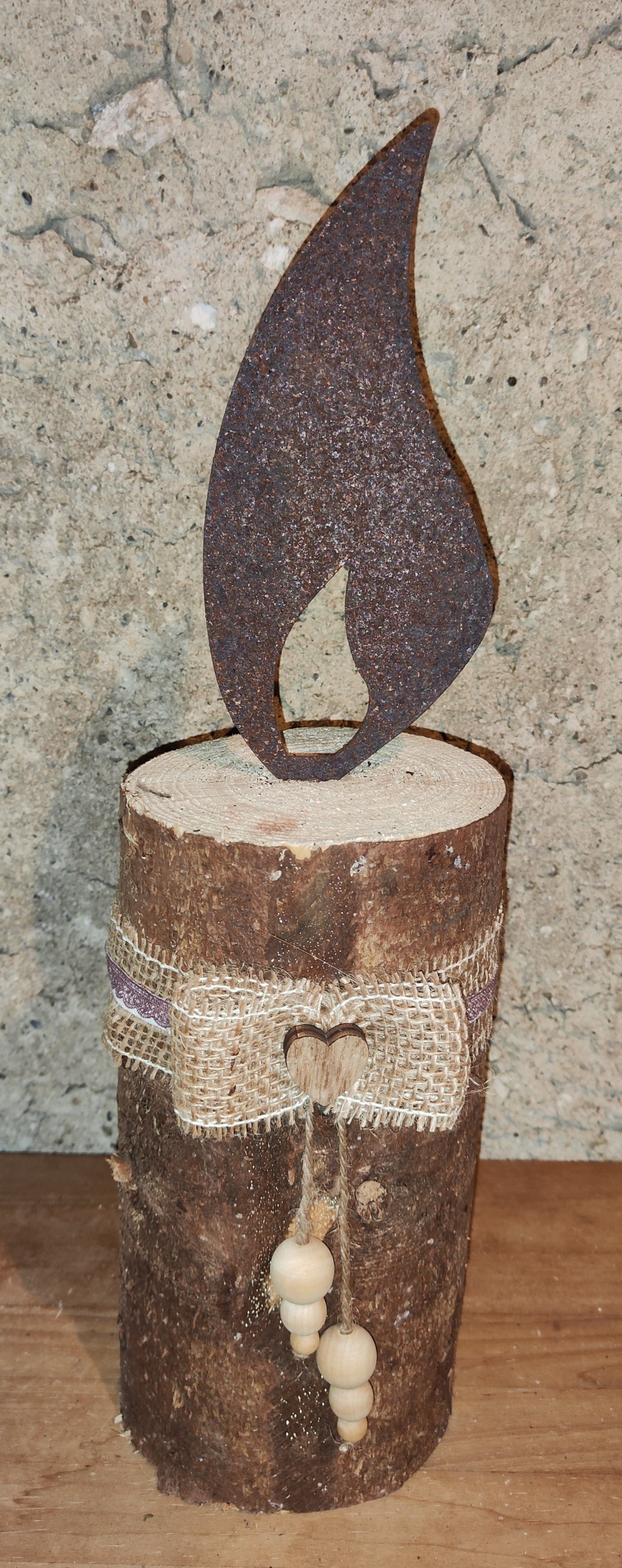 Rostkerze, Rostflamme, Edelrost Flamme in Rostoptik weihnachtlich, winterlich auf Baumstamm dekoriert, Weihnachten, Deko.