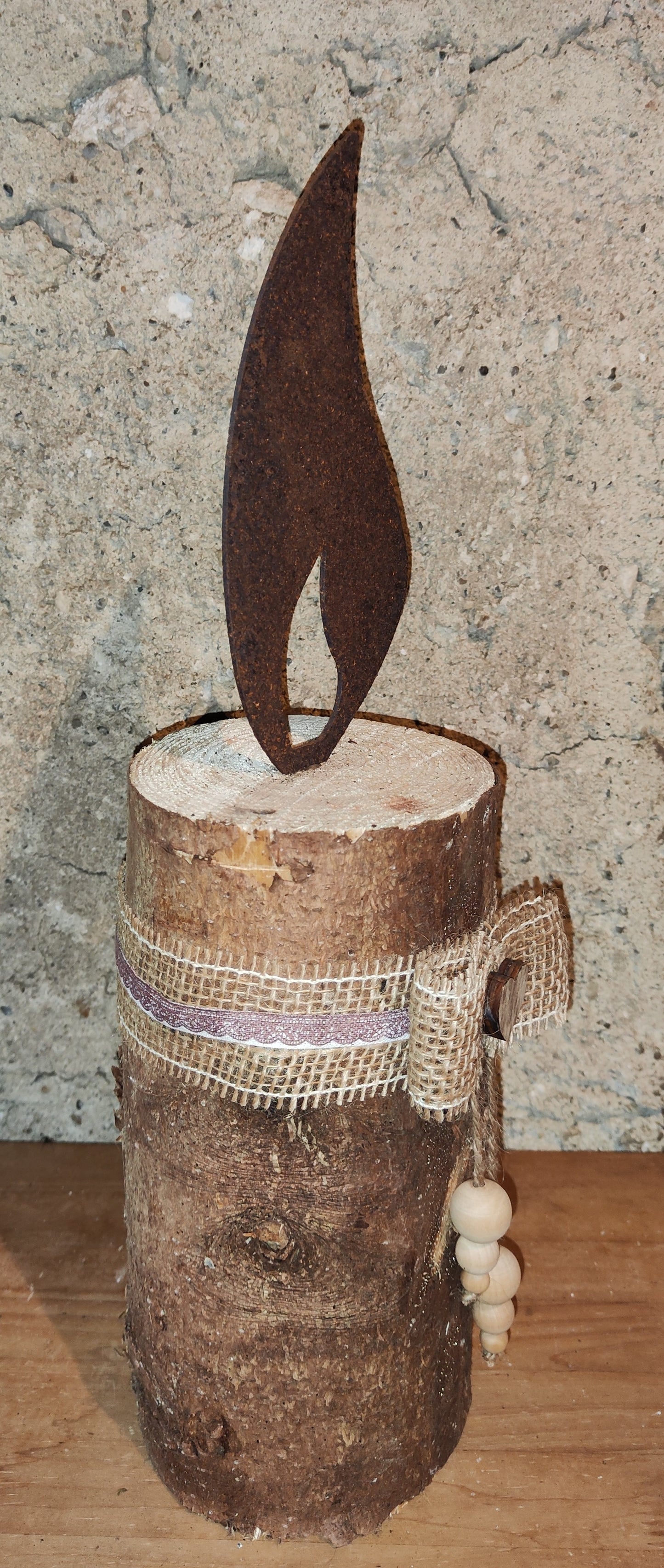 Rostkerze, Rostflamme, Edelrost Flamme in Rostoptik weihnachtlich, winterlich auf Baumstamm dekoriert, Weihnachten, Deko.