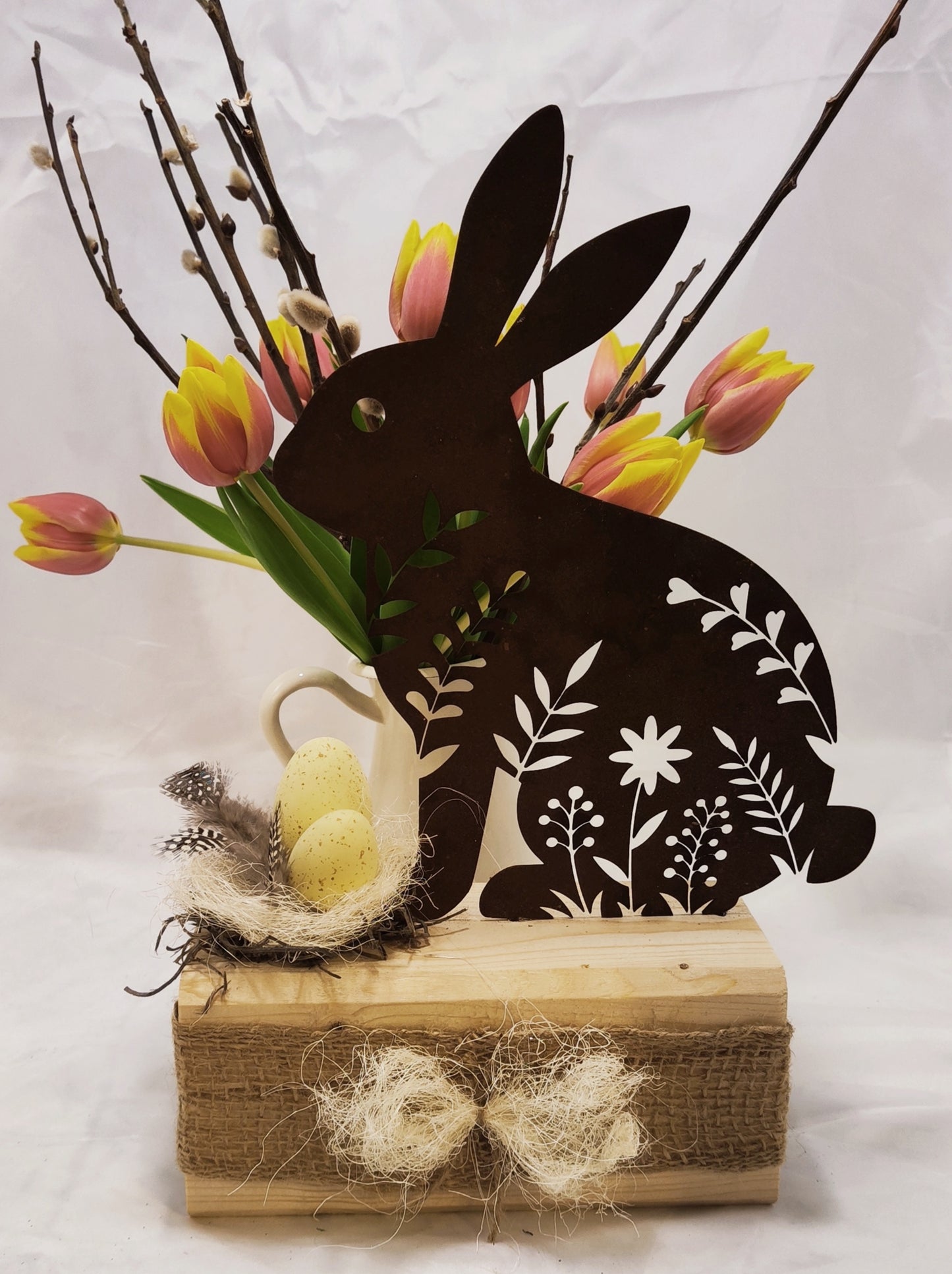 Hübscher filigraner Hase aus Stahl in Rostoptik auf Holz dekoriert