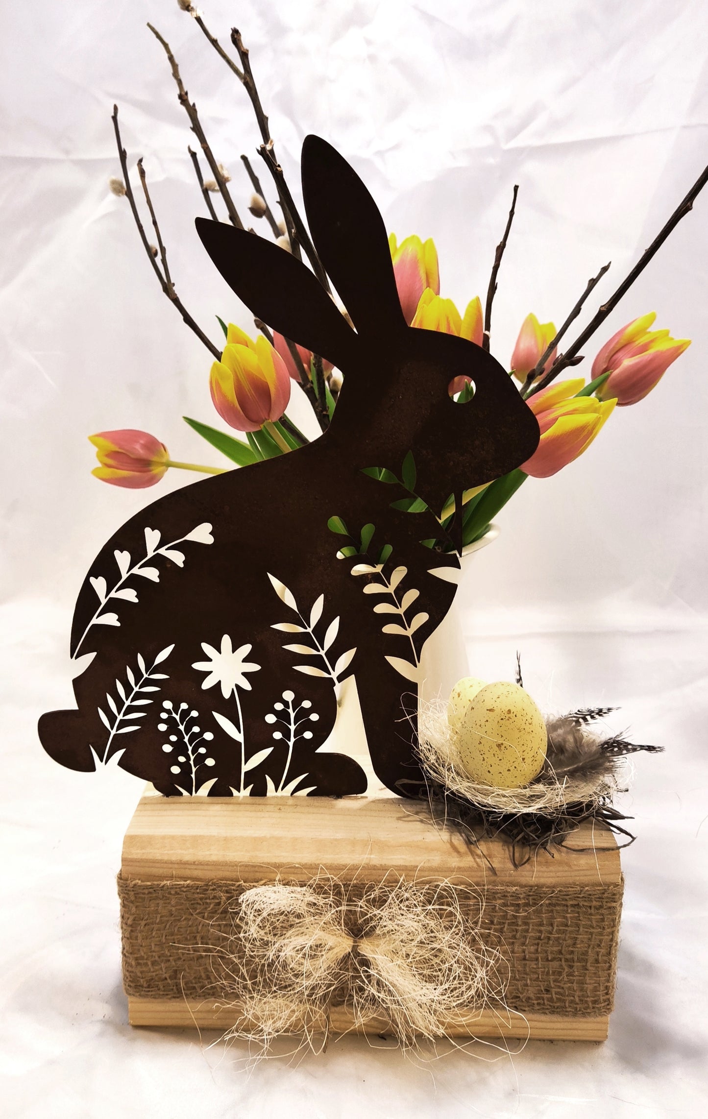 Hübscher filigraner Hase aus Stahl in Rostoptik auf Holz dekoriert