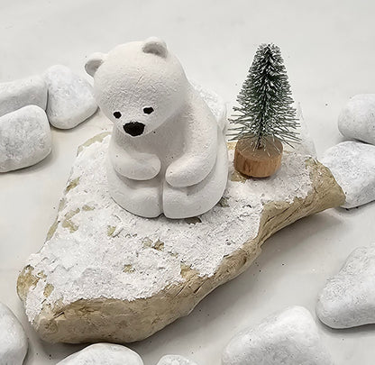 Kleine Eisbären auf Sandstein, teilweise mit Bäumchen.