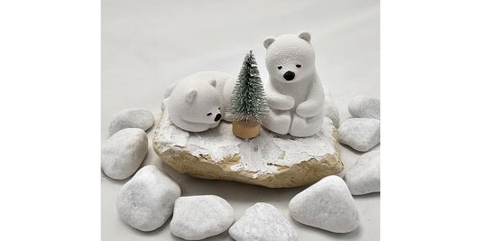 Kleine Eisbären auf Sandstein, teilweise mit Bäumchen.