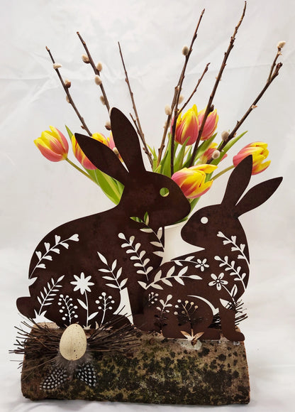 Hasen aus Stahl, in Rostoptik, österlich frühlingshaft auf Holz dekoriert