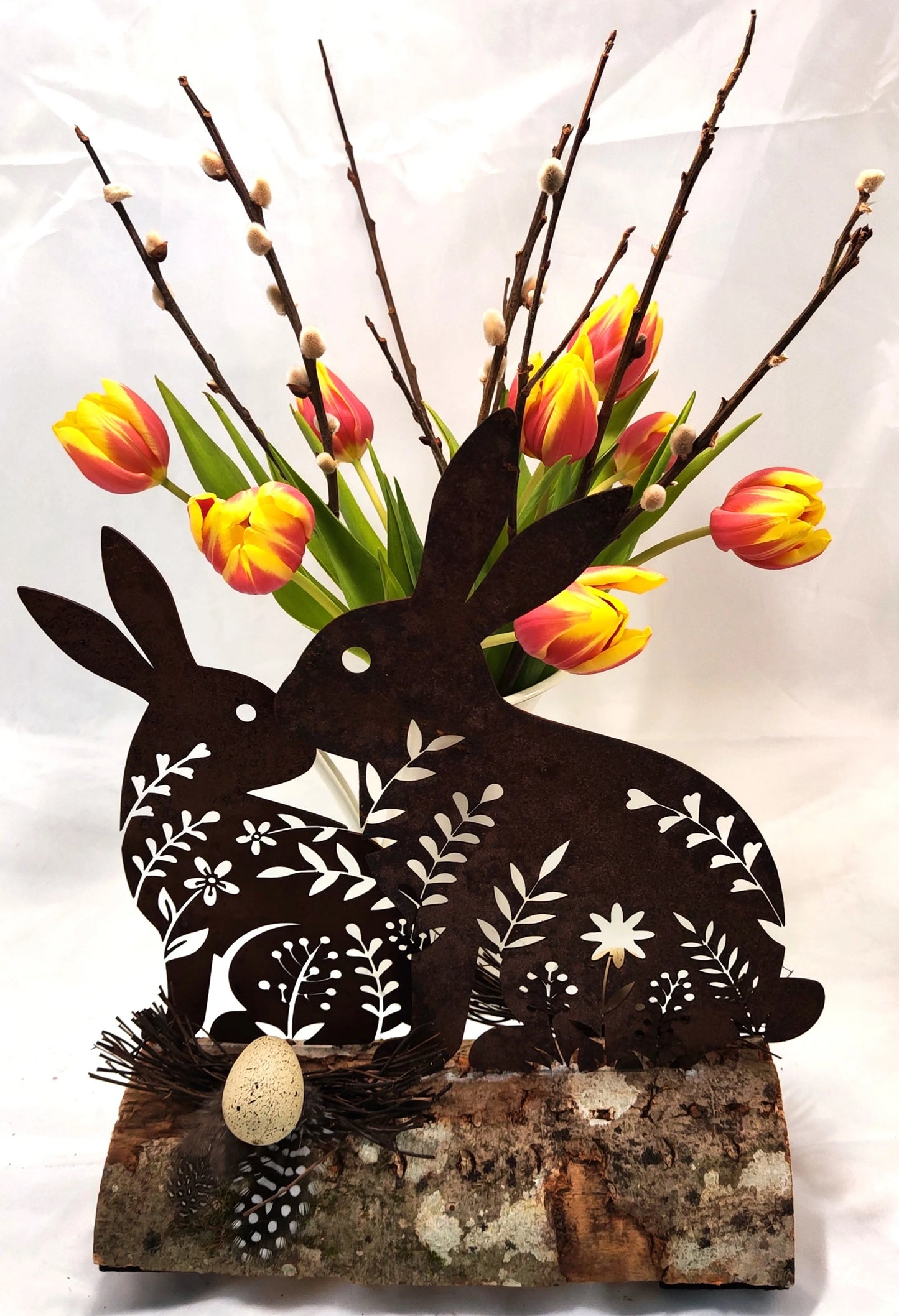 Hasen aus Stahl, in Rostoptik, österlich frühlingshaft auf Holz dekoriert